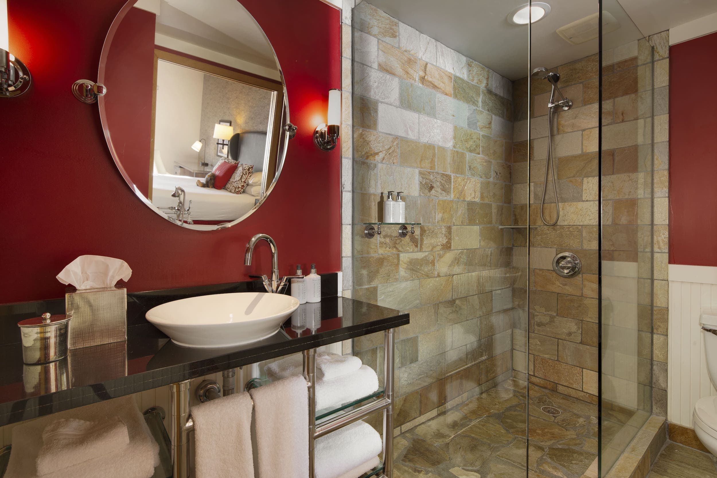 A washroom at Edgewater with a glass shower and black marble vanity