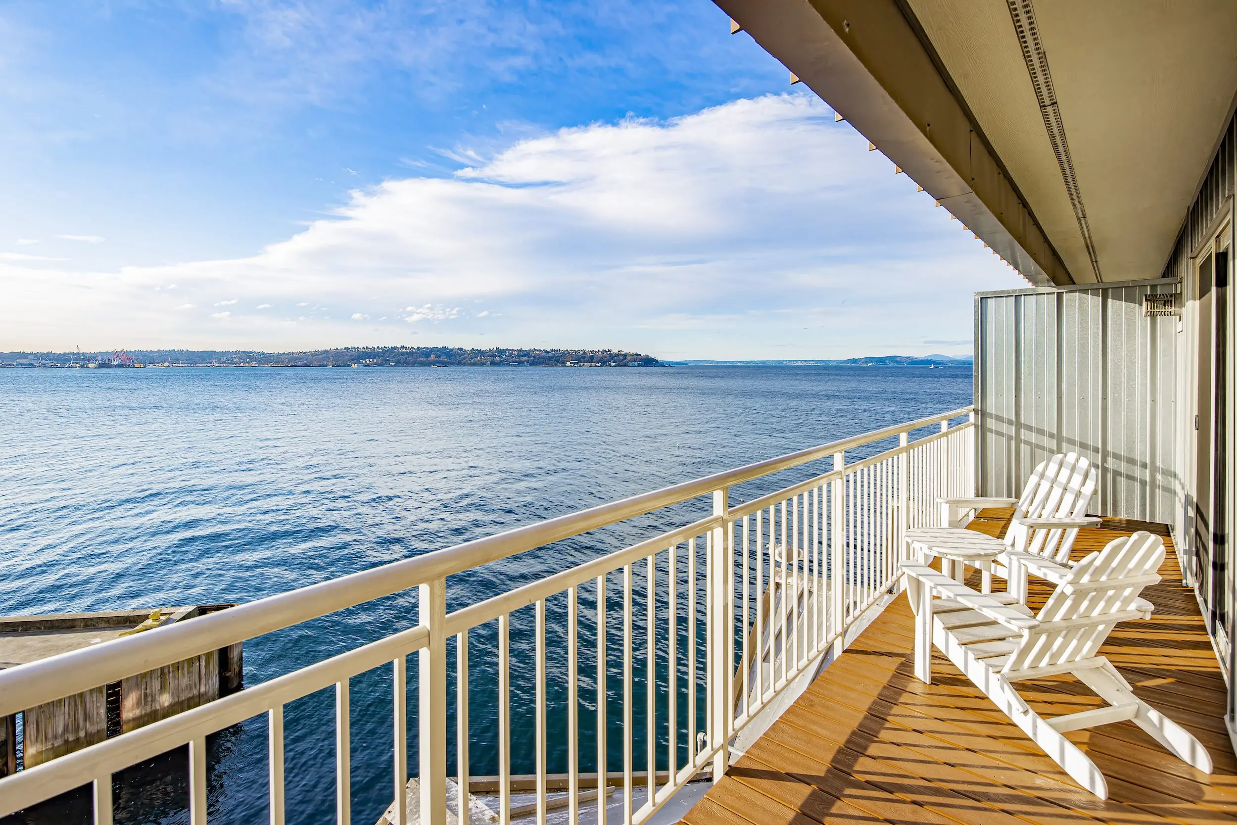 A balcony over looking the water with 2 lounge chairs at Edgewater