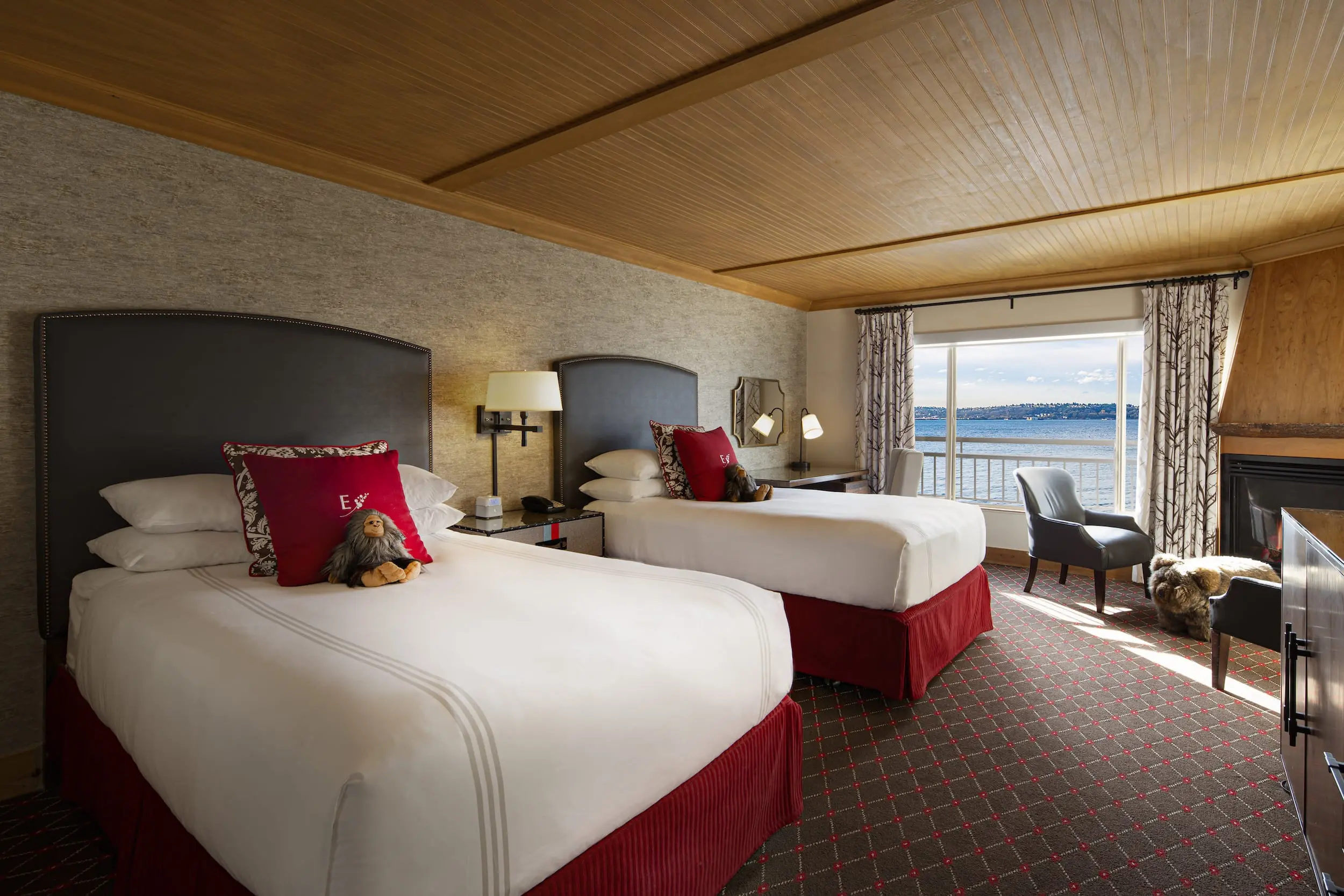 Two double beds with a balcony and a view of the water at Edgewater