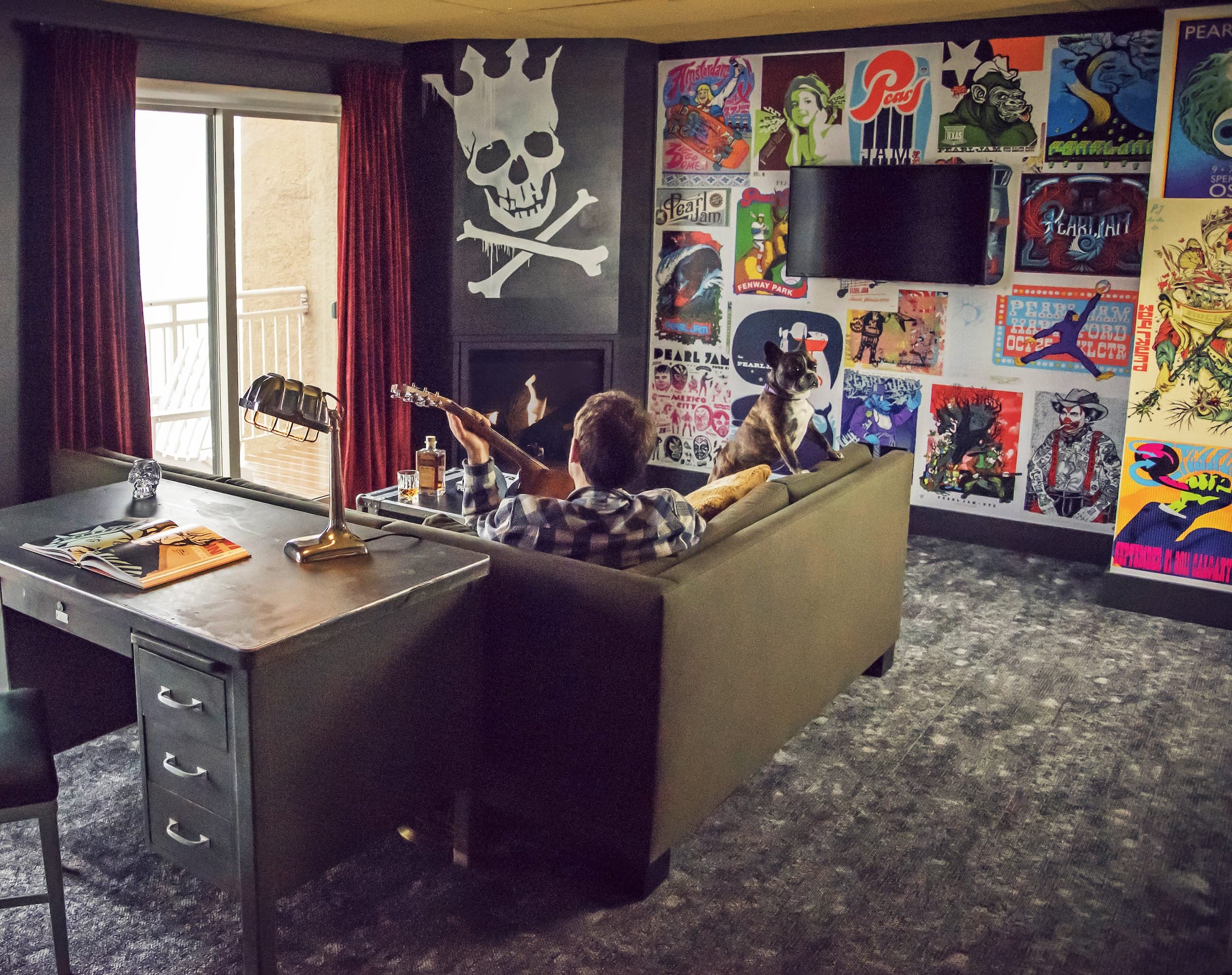 A man and his dog sitting on a couch in the Pearl Jam inspired room at Edgewater