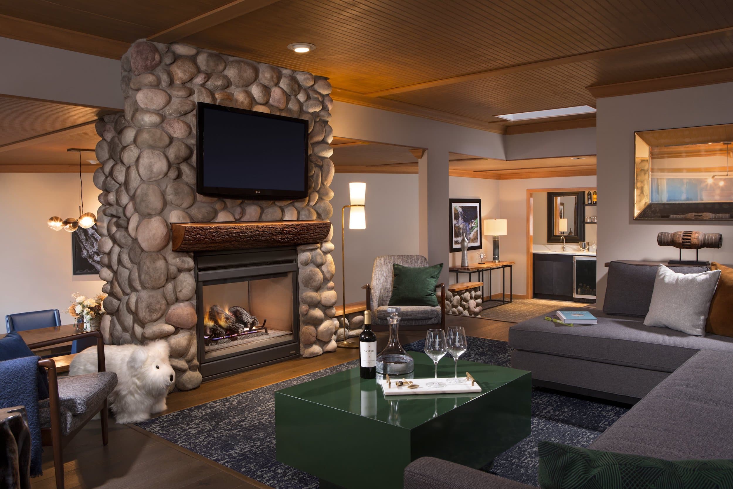 A gorgeous Penthouse living area with a stone fireplace, large sitting area and open concept room at Edgewater