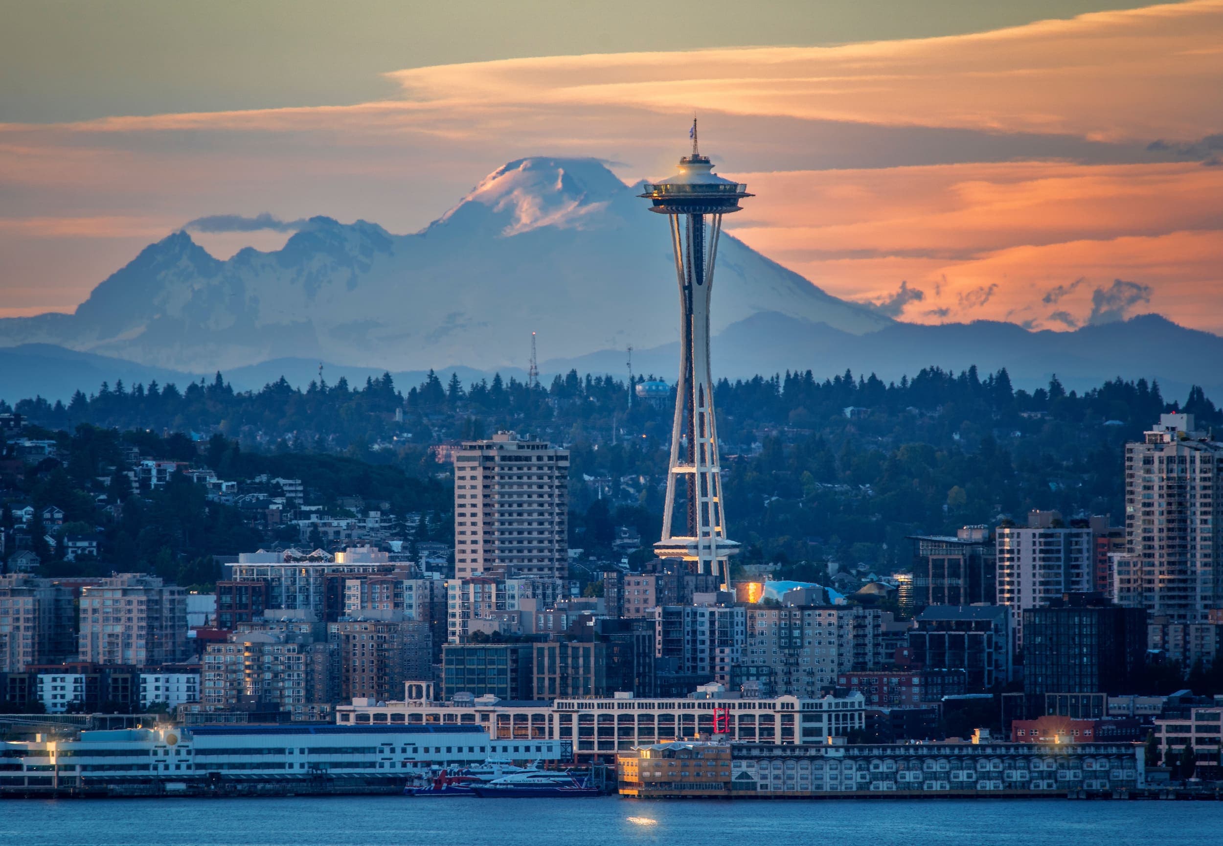 The Seattle Space Needle at sunset with the snowcapped mountains in the background