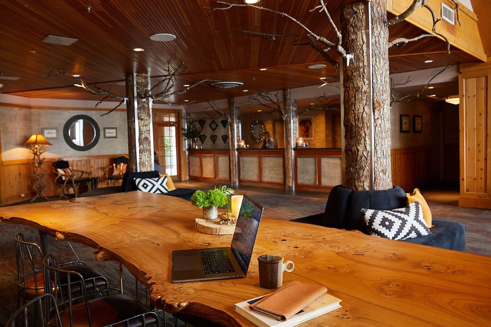 A beautiful live edge wood table in the Edgewater lobby with a laptop and coffee mug