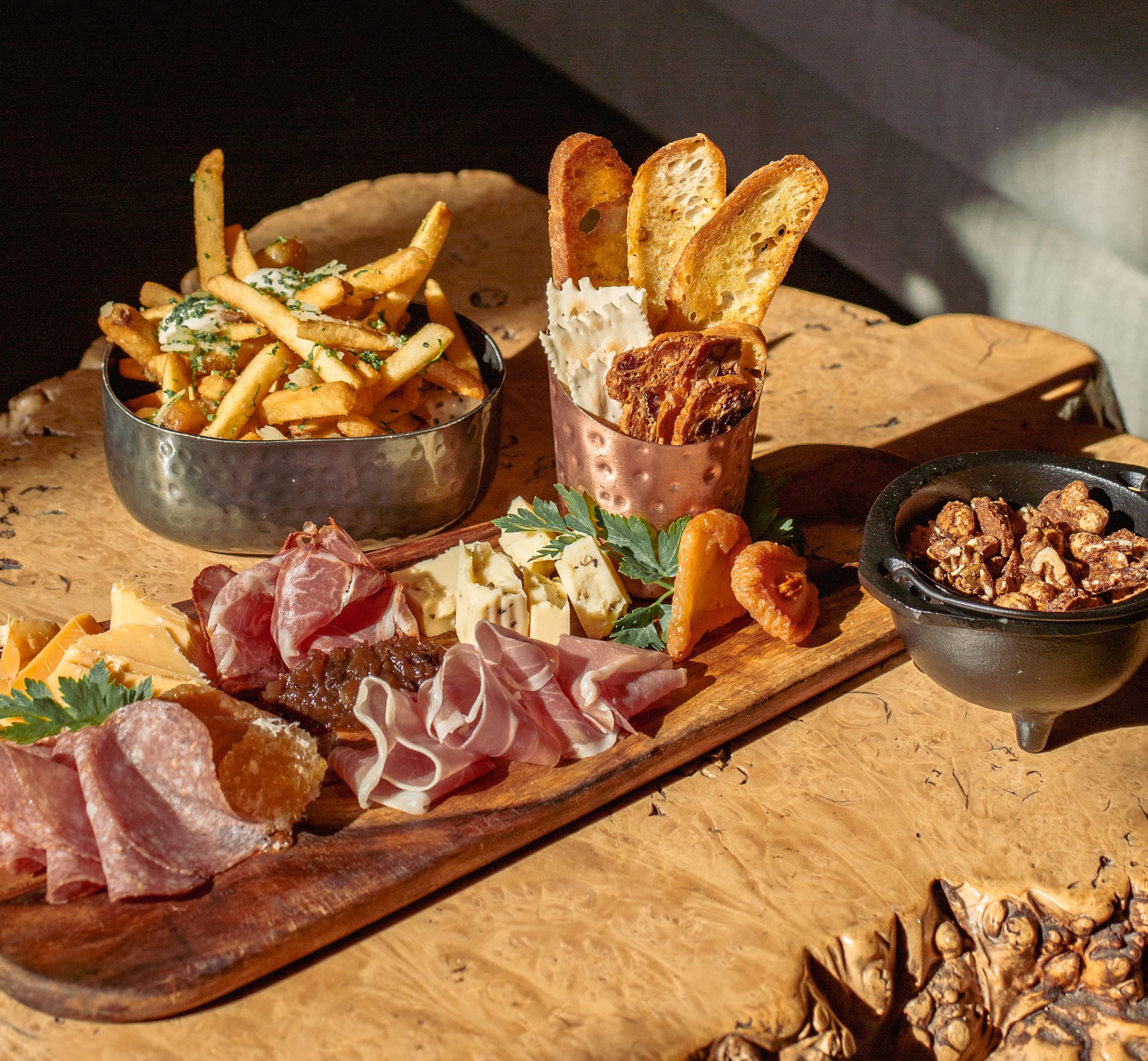 A charcuterie board, side of fries, and a small bowl of nuts at Edgewater