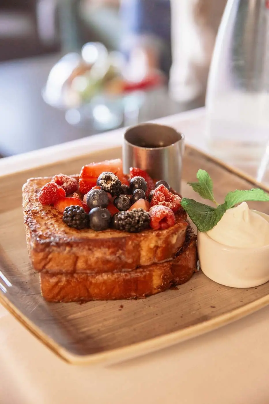 French toast with berries, whipped cream on the side and a side of syrup at Edgewater