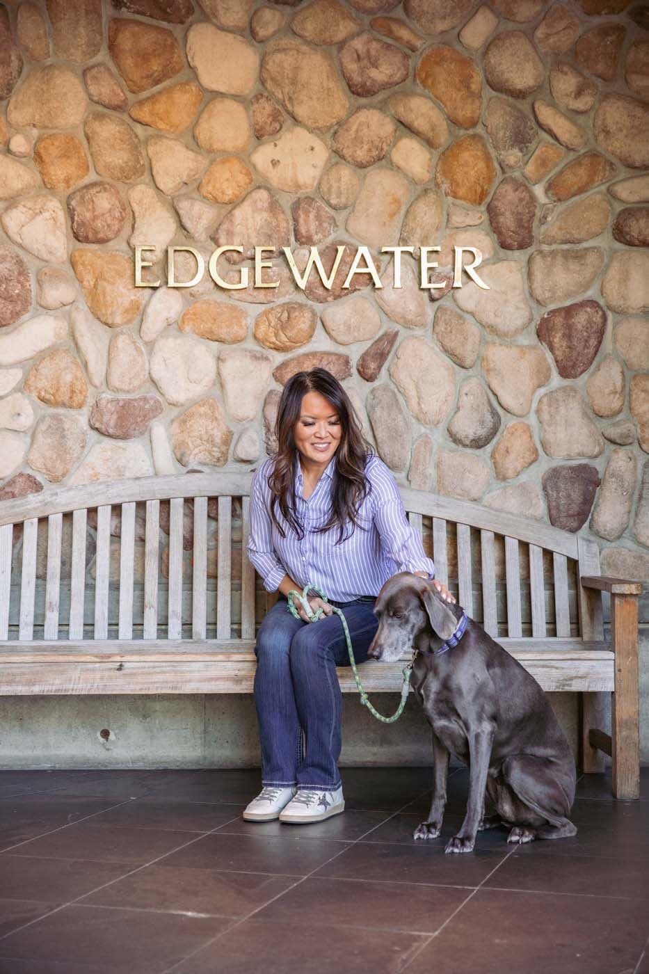 A woman petting a dog outside Edgewater