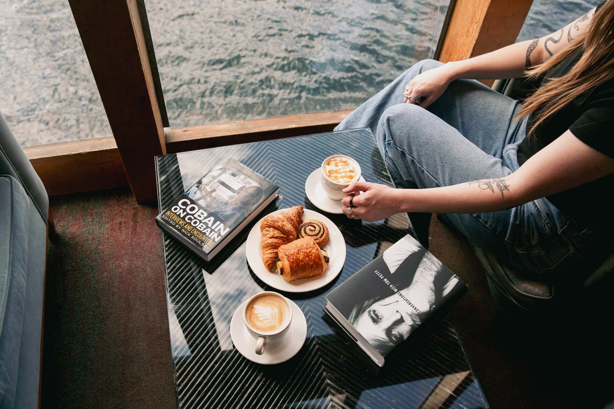 Two warm beverages and pastries on a coffee table at Edgewater