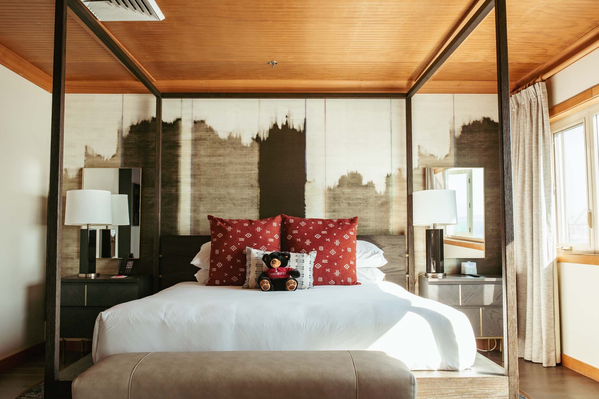 A large bed with a canopy and large bright windows with stunning views of the water at Edgewater